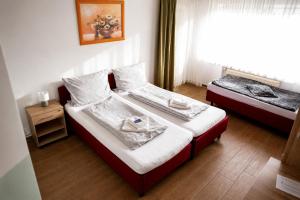 a bedroom with two beds and a window at Hotel Restaurant Neffelthal in Kerpen