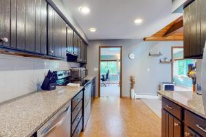 a kitchen with wooden cabinets and a counter top at Tree-lined home with screened porch & perfect Midcoast location in Damariscotta