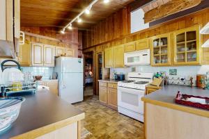 a kitchen with white appliances and wooden cabinets at Stunning artist's retreat with ocean view & amazing deck, near Reid State Park in Georgetown