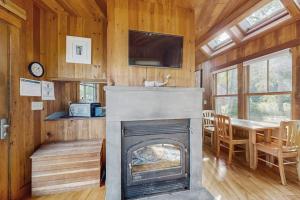a living room with a fireplace and a dining room at Waterfront Paradise with Dock, Big Yard, Sundeck & Epic Bay Views | Dog-Friendly in Boothbay