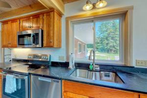eine Küche mit Edelstahlspüle und einem Fenster in der Unterkunft Bayfront home with gorgeous water views, dock, outdoor patio, fireplace in Bowdoinham