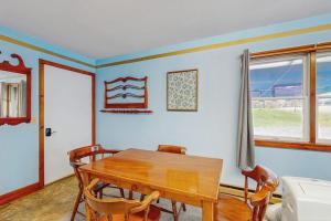 a dining room with a wooden table and chairs at Charming, single-level getaway with a full kitchen, fast WiFi, & grassy yard in Boothbay +23 photos