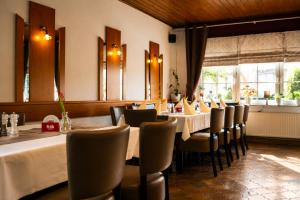 a dining room with tables and chairs and a window at Hotel Restaurant Neffelthal in Kerpen