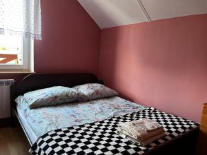 a small bedroom with a bed with a checkered floor at Chess Apartament in Augustów