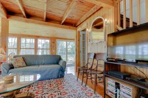 a living room with a blue couch and a tv at Charming Bayview Cottage with Deck, Firepit, Garden - 200 in East Harpswell