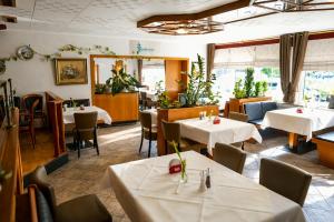 a dining room with white tables and chairs at Hotel Restaurant Neffelthal in Kerpen
