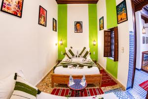 a bedroom with a bed with green and white walls at Dar Mayssa Fez in Fez