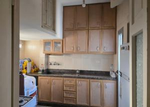a kitchen with wooden cabinets and a sink at Sea promenade Hostel Art Apartment in El Mîna +58 photos