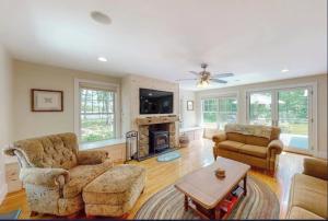 a living room filled with furniture and a fireplace at Secluded lakefront home with patio & firepit, fast WiFi, wood stove & W/D in Ellsworth