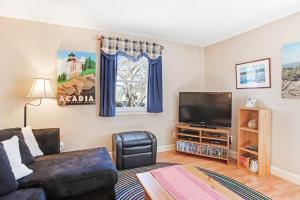 a living room with a couch and a flat screen tv at Dog-friendly home in great locale close to the ocean with yard, streaming, W/D in Tremont