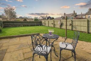 a patio with a table and chairs in a yard at 2 Bed in Warkworth oc-coq95 in Warkworth