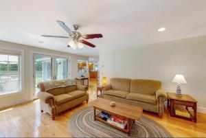 a living room with two couches and a ceiling fan at Secluded lakefront home with patio & firepit, fast WiFi, wood stove & W/D in Ellsworth