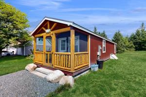 a large wooden cabin in a field of grass at Charming Coastal Retreat with Ocean Views, Porch and Private Cabin in Sullivan