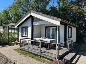 a small house with a porch and a table at Oase van rust in Poortvliet