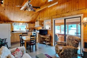a kitchen and living room with a table and chairs at Lakefront, cabin-inspired home with firepit, grill, & screened porch, Wifi in Greenville