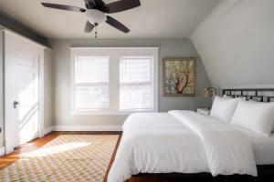 a bedroom with a white bed and a ceiling fan at Robin's Egg, Private Downtown, Pet-Friendly Gem in Columbus