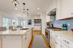 a kitchen with white cabinets and a counter top at Elegant home with veranda & water view, walk to downtown Boothbay Harbor in Boothbay Harbor