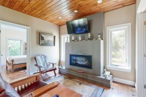 a living room with a fireplace and a wooden ceiling at Dog-friendly home with high-speed WiFi, washer/dryer, & private dock in Cundys Harbor