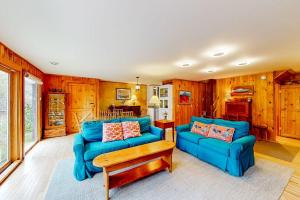 a living room with two blue couches and a table at Dog-friendly ocean-view duplex with wood stoves, decks, grills, kitchens, ACs in Southwest Harbor