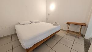 a small bed in a room with a table at Aruma Stays in Brisas de Zicatela