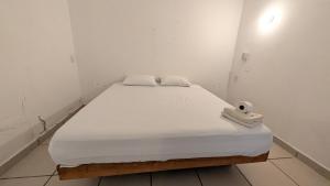 a bed in a white room with at Aruma Stays in Brisas de Zicatela