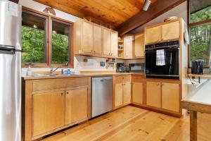a kitchen with wooden cabinets and a refrigerator at Beautiful hidden Waterfront Retreat with Rocky Beach in Boothbay +21 photos