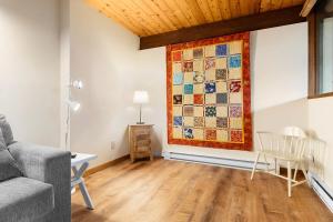 a living room with a quilt hanging on the wall at Beautiful hidden Waterfront Retreat with Rocky Beach in Boothbay