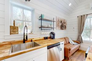 a kitchen with a sink and a couch at Brand-new dog-friendly home near Hancock Pond with firepit, grill, streaming, AC in Bucksport
