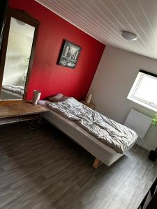 a bedroom with a bed and a red wall at Eventyrborgen in Eskilstrup