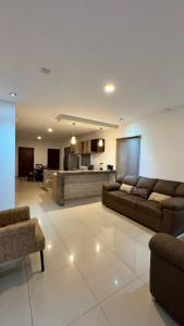 a living room with two couches and a kitchen at Departamento moderno en Durango in Durango