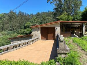 a building with a wooden door and a walkway at Casa Do Conde in Caldas de Reis
