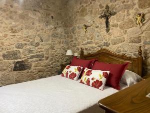 a bedroom with a bed with a cross on the wall at Casa Do Conde in Caldas de Reis