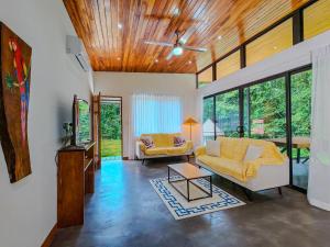 a living room with two couches and a tv at Samara by the River Vacation Suites in Sámara