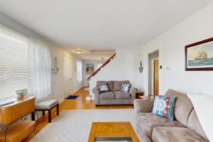 a living room with a couch and a table at Charming Coastal House with Cozy Living Spaces and Outdoor Firepit in Winter Harbor