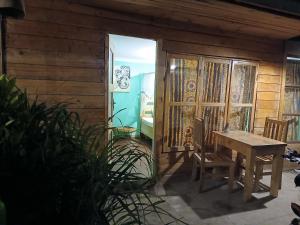a wooden house with a table and chairs in a room at Patience Airport cottages in Boma la Ngombe