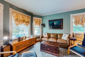 a living room with a couch and some windows at Dog-friendly historical home with recent updates, porch & prime in-town location in Rockland +23 photos