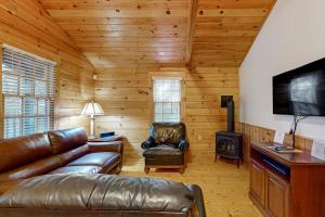 a living room with leather furniture and a flat screen tv at Comfortable two bedroom cabin with firepit, kitchen, hiking trail within walking in Northport