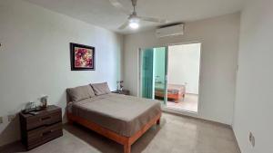 a bedroom with a bed and a dresser and a window at Casa Corazón de Boca, steps from the beach and restaurants in Boca del Río