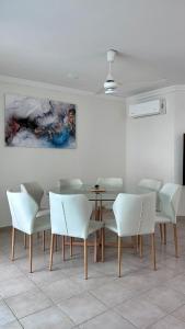 a dining room with a table and white chairs at Casa Corazón de Boca, steps from the beach and restaurants in Boca del Río