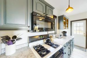a kitchen with a stove top oven next to a counter at Newly Renovated Haven w/ Deck, Walk to Shops, Dining & Marina, Pet friendly in Boothbay Harbor +27 photos
