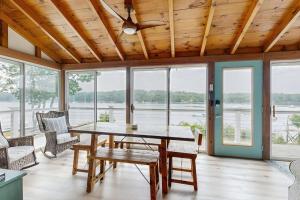 a dining room with a table and chairs and windows at Charming Oceanfront Home with Stunning Water Views and Wifi in Georgetown