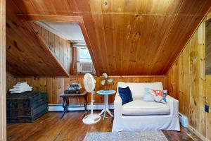 a living room with a white couch and a wooden ceiling at Historic Boothbay Harbor cottage with antique decor, washer/dryer & deck in Boothbay Harbor +17 photos