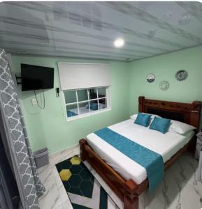 a bedroom with a bed and a tv in a room at Posada MaiMai in Providencia