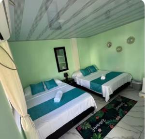 a room with two beds in a room at Posada MaiMai in Providencia +3 photos
