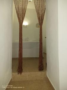 two tall brown curtains in a bathroom with a tub at ''RENATA'' Studio in Kithnos