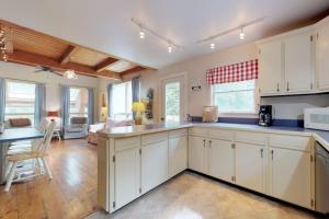 a kitchen with white cabinets and a living room at Home with deck, great location in the heart of Acadia National Park in Otter Creek