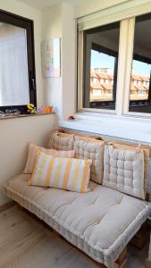 a white couch in a room with two windows at Appartement L'esprit marin in Villers-sur-Mer +5 photos