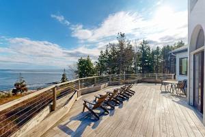 a deck with benches and a view of the ocean at Private Oceanfront Home -- 2 Fireplaces, 4 Decks & Grill, Dog-friendly in East Boothbay