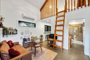 a living room with a couch and a staircase at Cliff Hot Tub with Deck Fire Pit Mural and Pet Friendly in Rogers