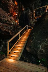 a wooden staircase leading into a cave at night at Cliff Hot Tub with Deck Fire Pit Mural and Pet Friendly in Rogers